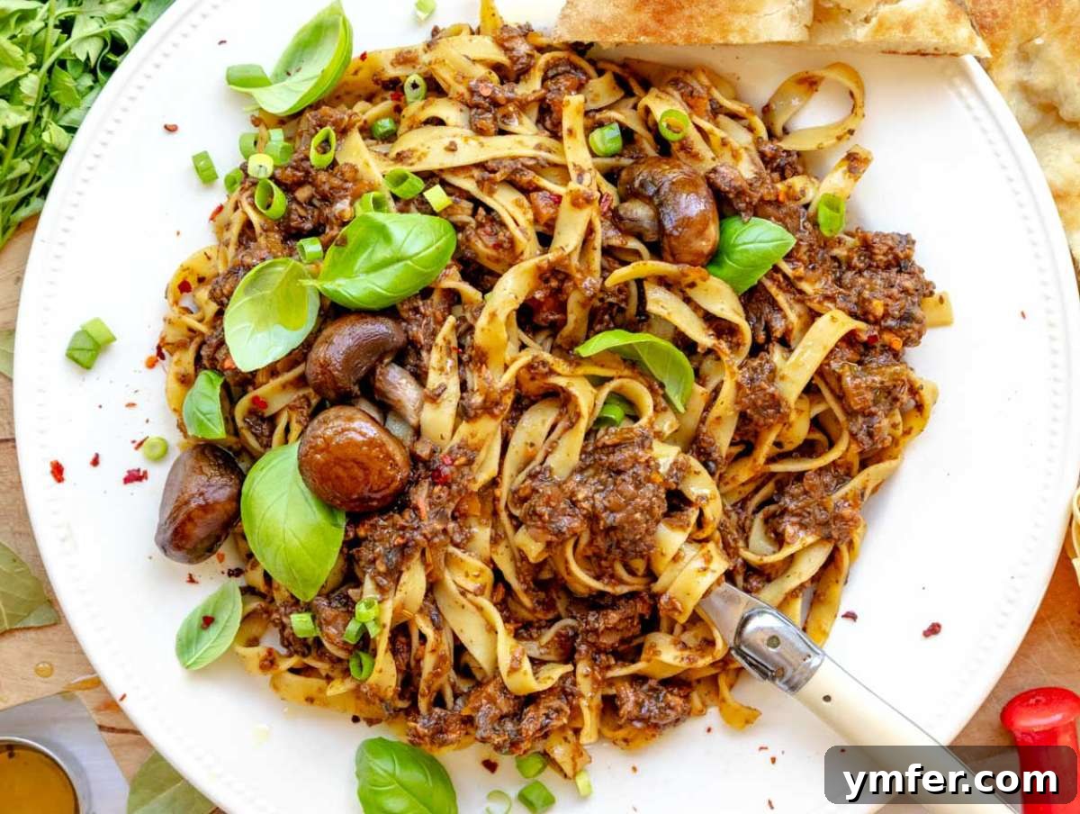 25 Affordable and Healthy Mediterranean Diet Meals 14 Mediterranean mushroom pasta served on a plate with fresh basil.
