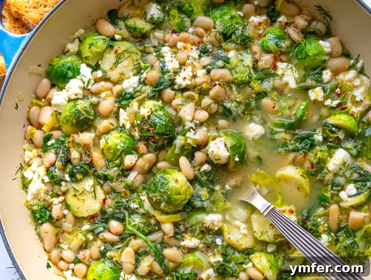 25 Affordable and Healthy Mediterranean Diet Meals 21 Close up of bright Mediterranean greens and beans topped with feta and fresh herbs.