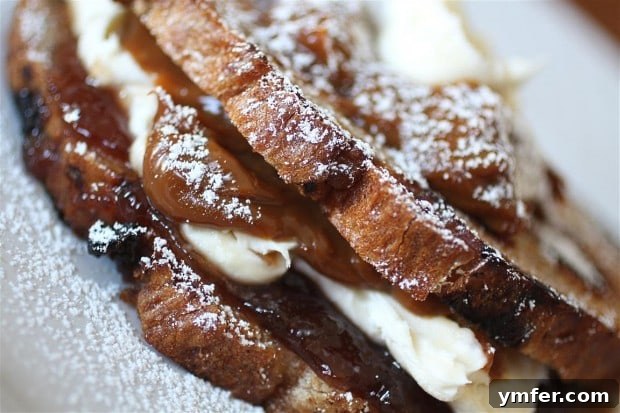 A perfectly grilled Bianca Dessert Grilled Cheese sandwich, showing the warm, gooey filling of dulce de leche, mascarpone, and raspberry jam.