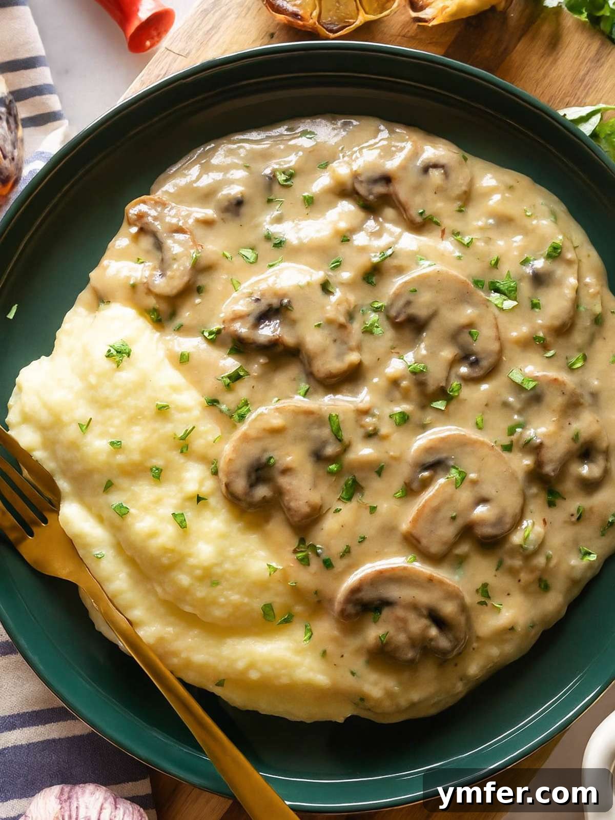 Mushroom sauce topping a plate of garlic mashed potatoes served on a festive table, highlighting its rich, brown color and inviting texture.