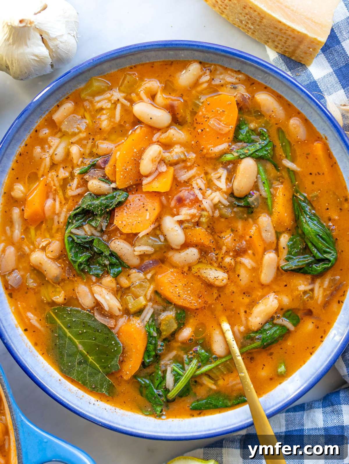 Hearty Greek Bean and Rice Stew Fasolada Inspired 4 Top down of a Greek bean stew with rice in a blue bowl, garnished and ready to serve.
