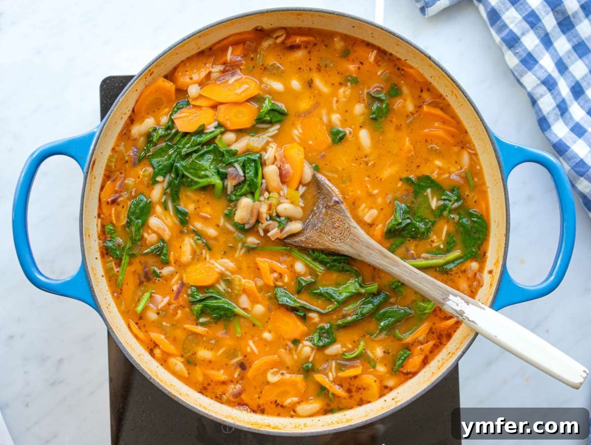 Hearty Greek Bean and Rice Stew Fasolada Inspired 8 Step four: finishing the Greek bean stew with spinach, stirring until just wilted.