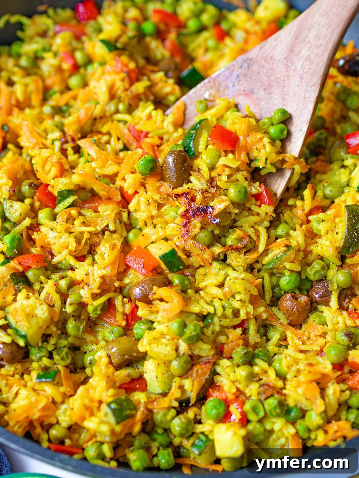 Golden Mediterranean Turmeric Vegetable Skillet 2 Golden veggie skillet with peas zucchini carrots and Mediterranean stir fried rice.