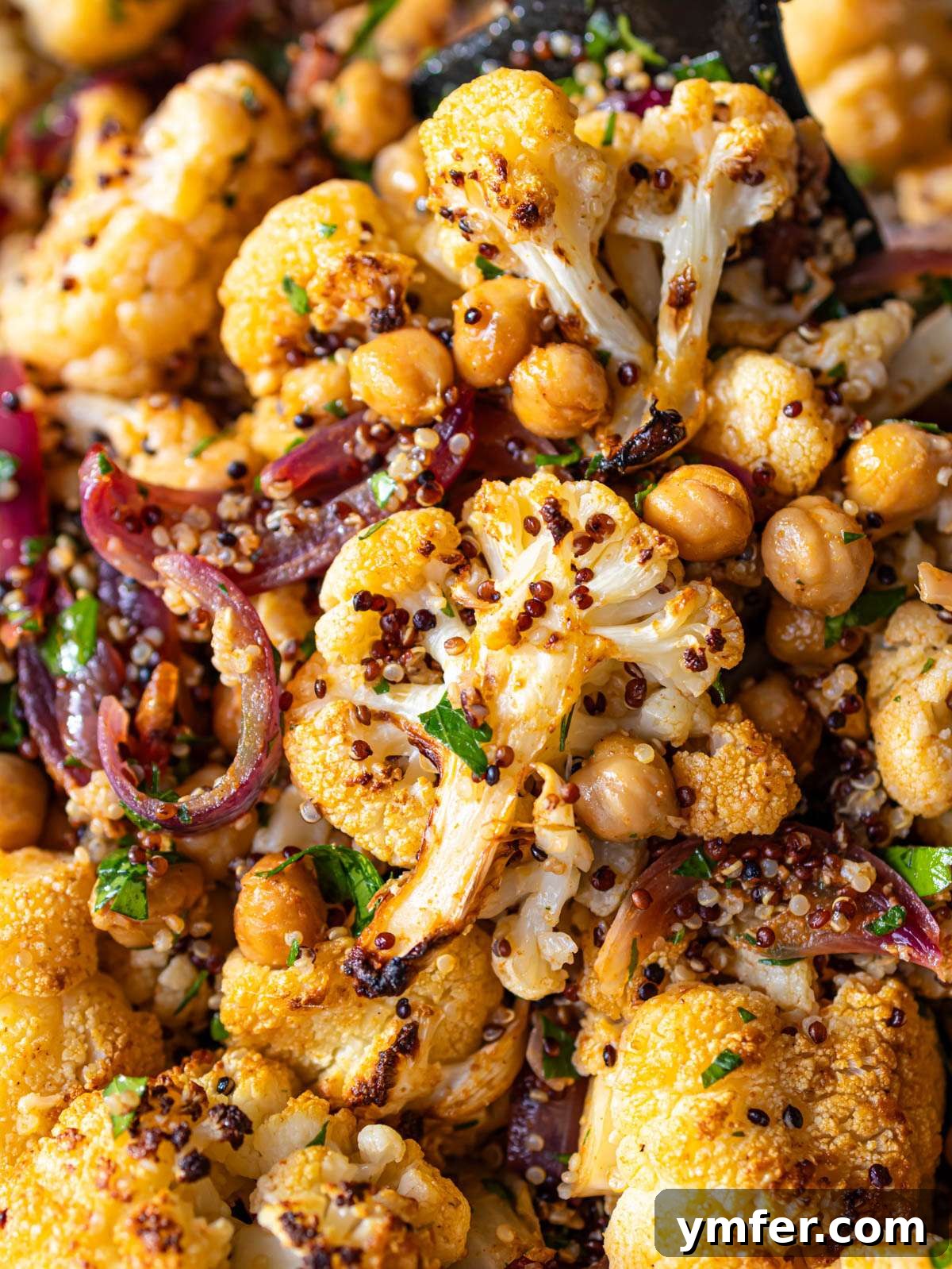 Close up cauliflower shawarma bowl cooked on a sheet pan with roasted veggies and quinoa.
