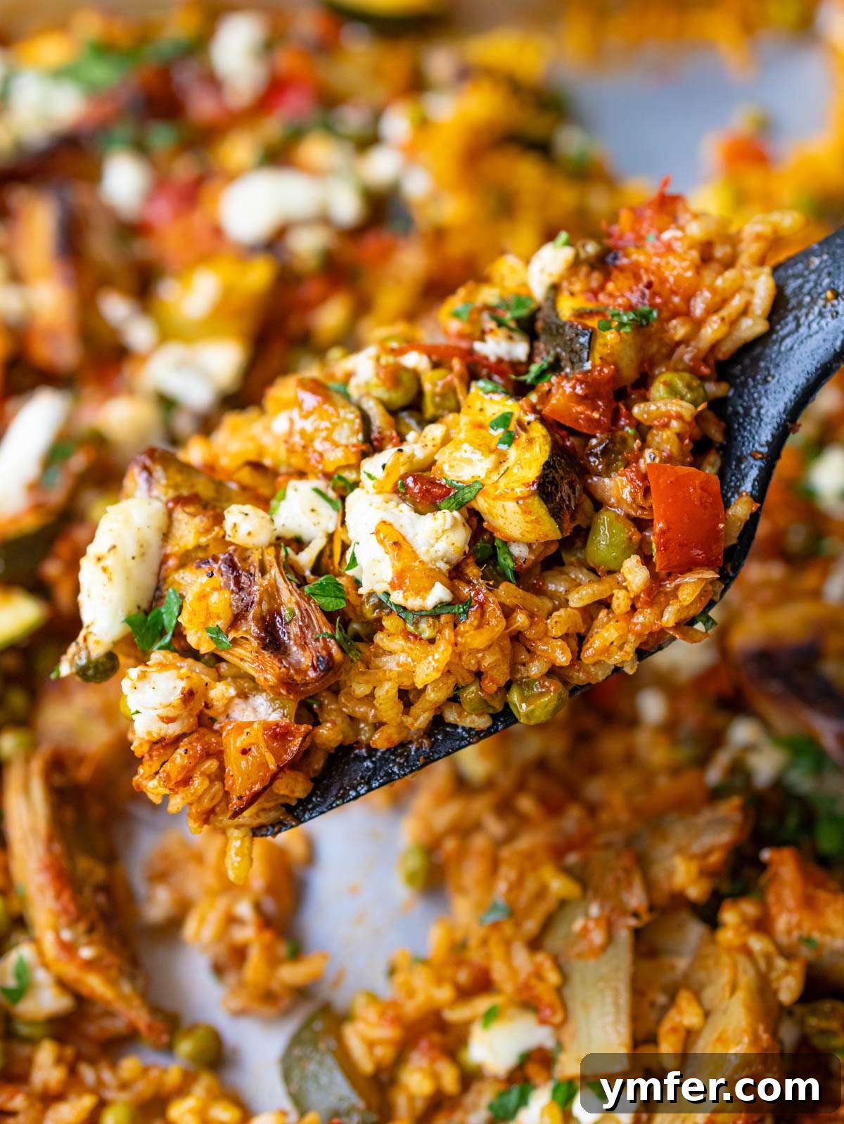 Effortless One-Pan Vegetable Paella 2 Finished dish close up Vegetable Paella with tender rice and roasted veggies on sheet pan.
