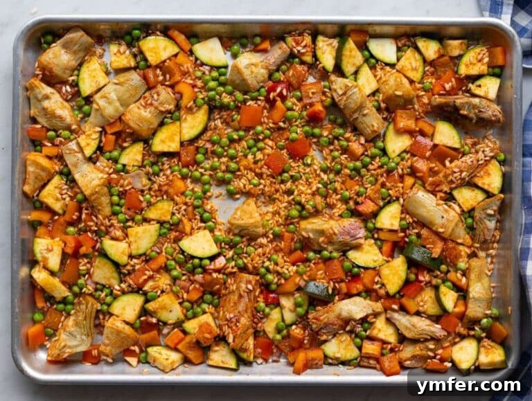 Effortless One-Pan Vegetable Paella 10 Step one Veggies rice and spices mixed on sheet pan.