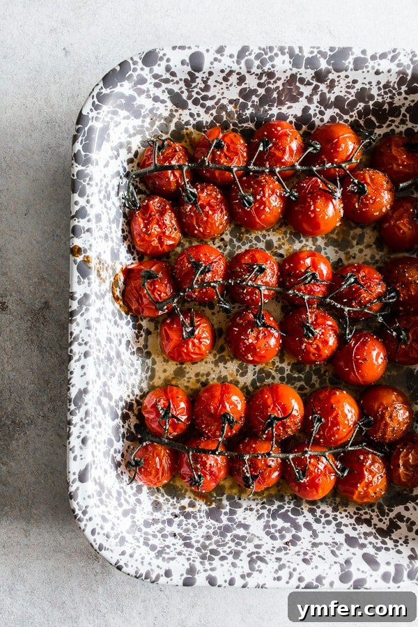 Roasted Tomatoes on the Vine 3 A tray filled with a generous batch of on the vine roasted tomatoes, showcasing their rich color and texture.