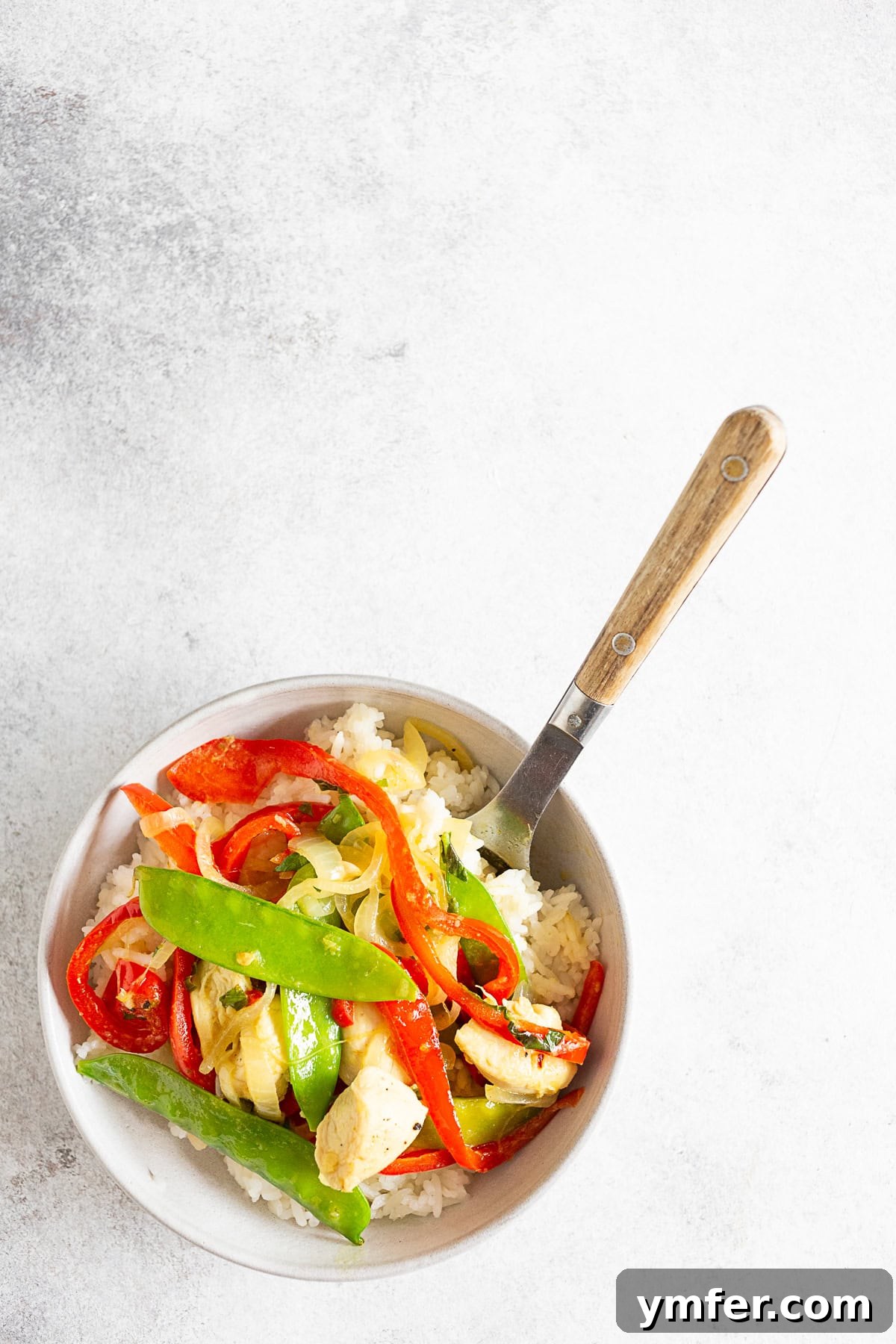 Emerald Chicken Curry 4 A serving of green chicken curry in a white bowl with a spoon, highlighting the vibrant colors and rich texture.