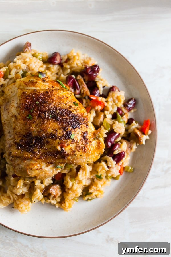 Smoky Cajun Chicken Rice Pot 5 A serving of One Pot Cajun Chicken and Rice spooned onto a white plate, ready to be enjoyed.