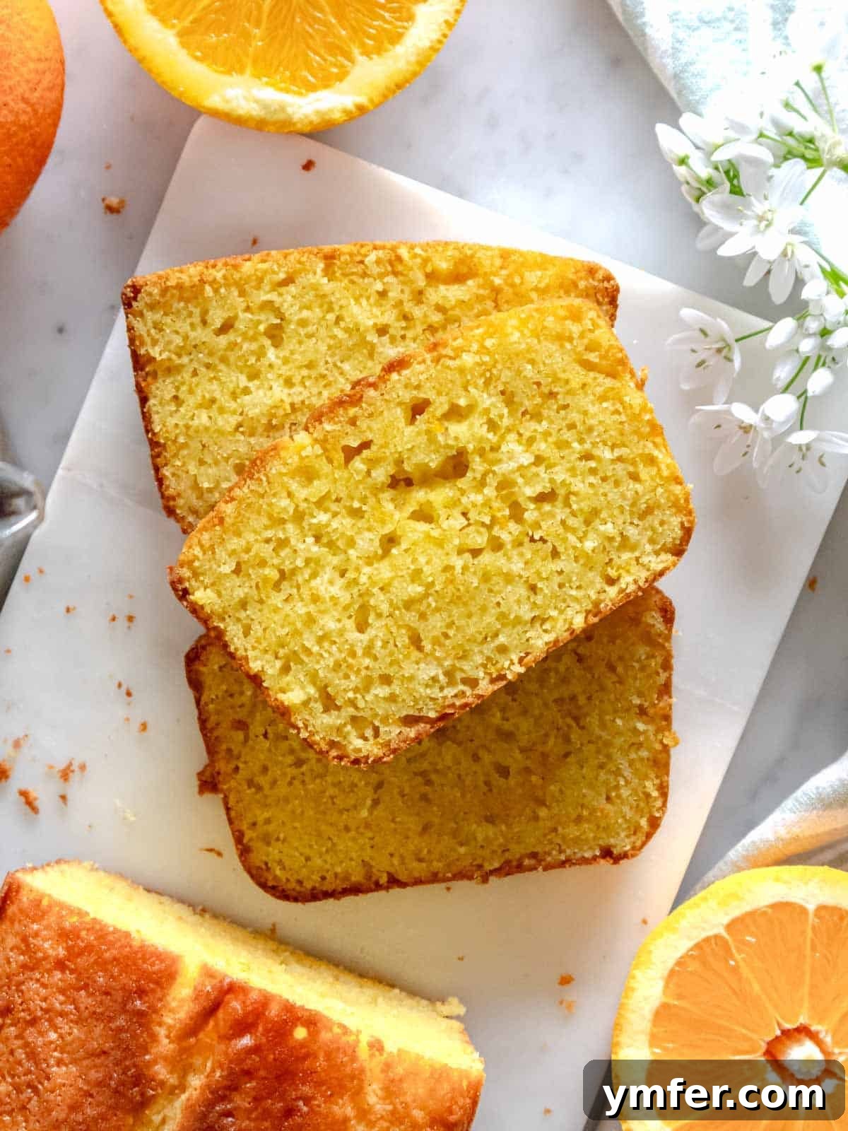 Zesty Orange Bliss Cake 2 Slices of fluffy and moist orange cake drizzled with orange syrup, garnished with a sprig of mint or orange peel.