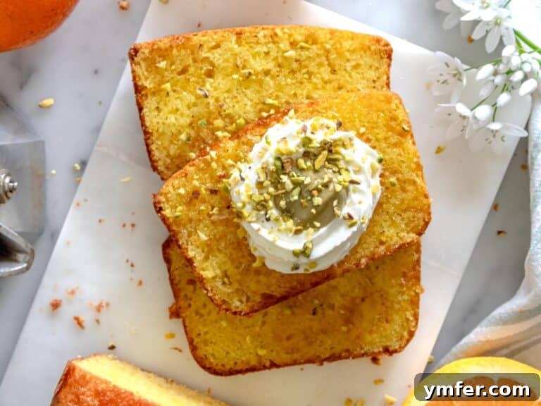 Zesty Orange Bliss Cake 13 Orange cake slices garnished with pistachio butter and whipped cream, ready for serving.