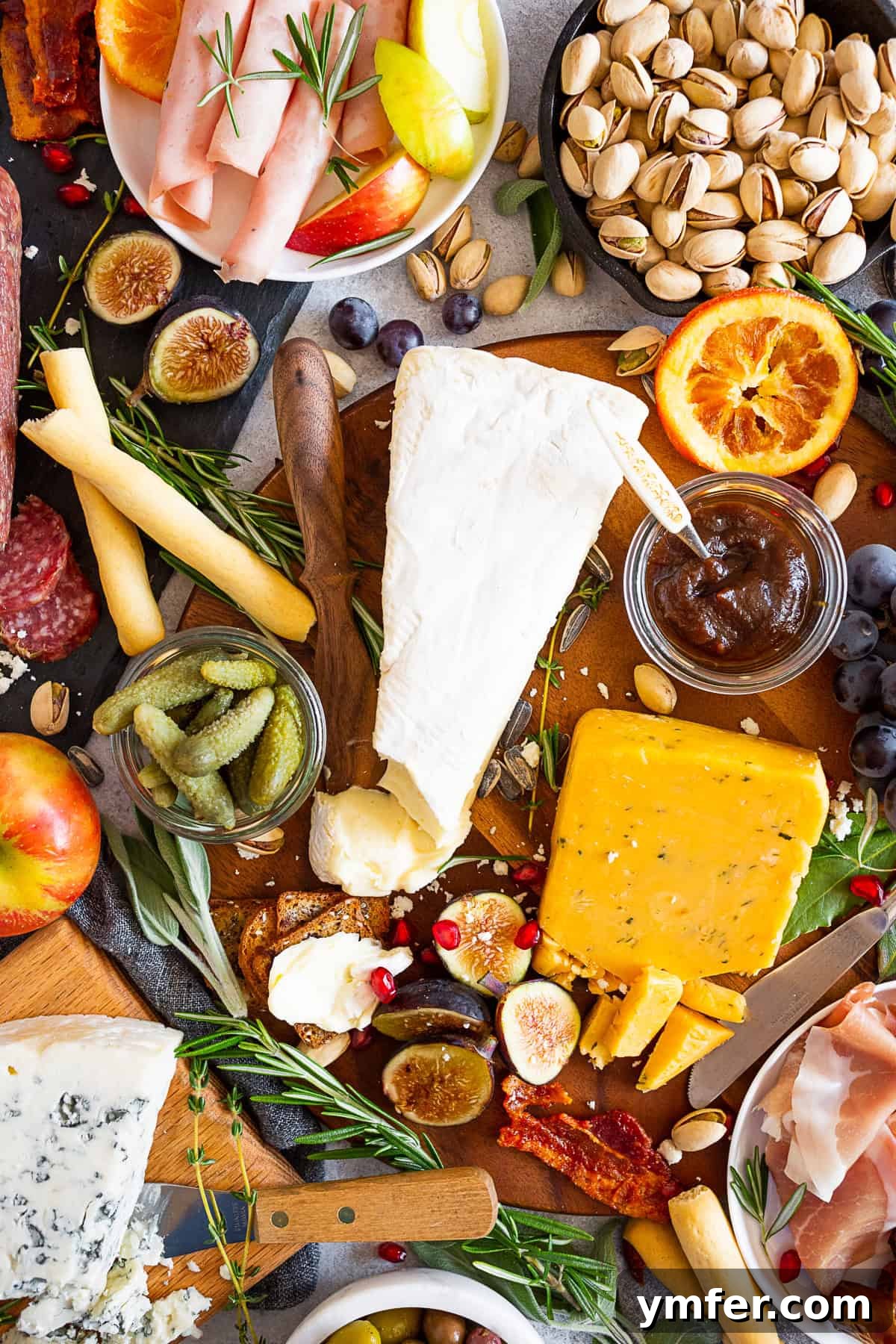 Fall Cheese Board on a table, showcasing a rich variety of cheeses, meats, fruits, and crackers.