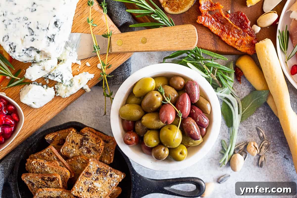 Gorgonzola cheese, seeds cracker, and olives on a table, ready for a fall cheese board.