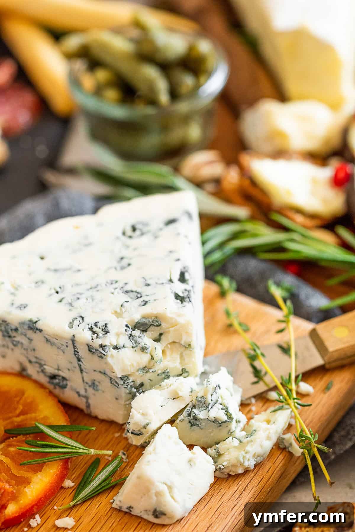 Fall Cheese Board shot of a wedge of gorgonzola cheese, highlighting its texture and color.