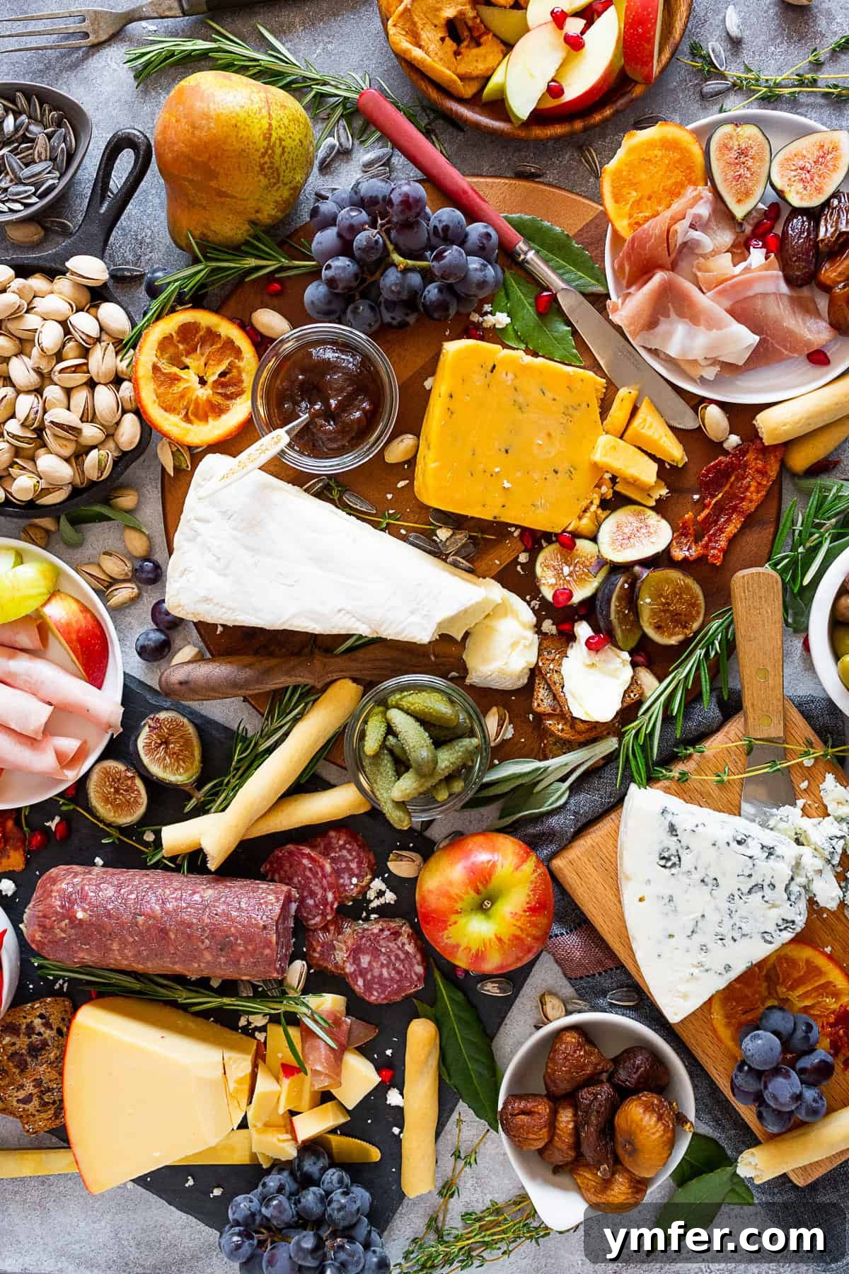 Fall Cheese Board decorated with fresh herbs and a variety of autumn ingredients.