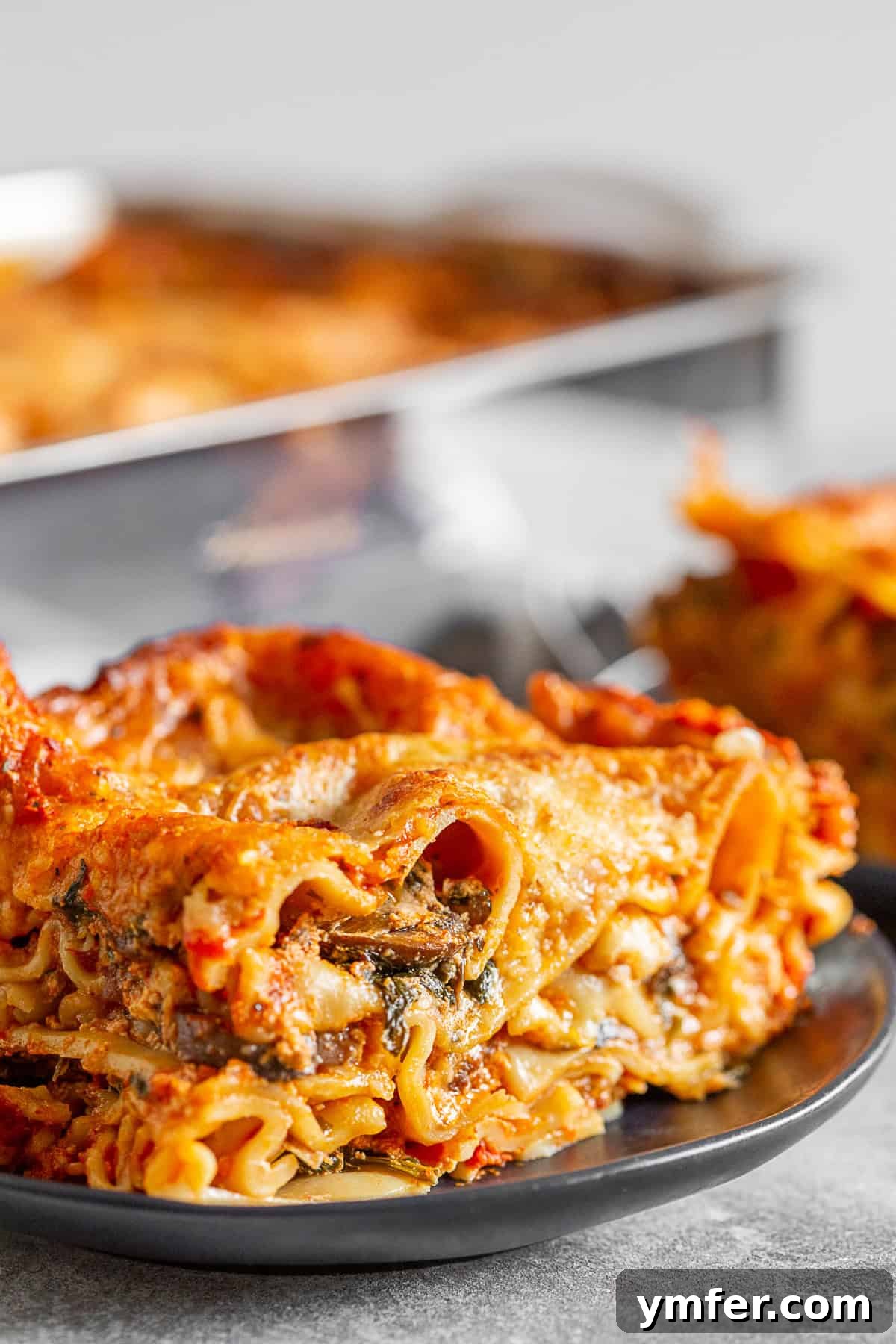 Hearty Italian Sausage Lasagna 6 A single slice of Italian Sausage Lasagna on a white plate, showcasing its rich layers.