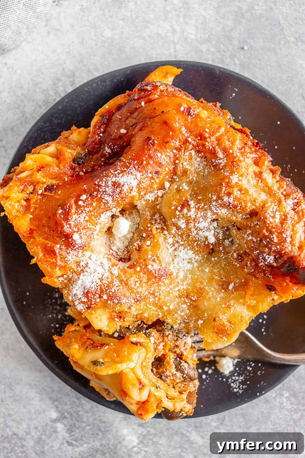 Hearty Italian Sausage Lasagna 7 A plate of Italian Sausage Lasagna with a fork, ready for a delicious bite.