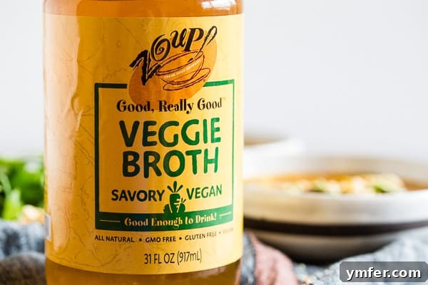 Warming Vegan Pumpkin Red Curry Noodle Soup 4 A jar of rich, golden vegetable broth, a key liquid component for this flavorful Vegan Red Curry Pumpkin Noodle Soup.