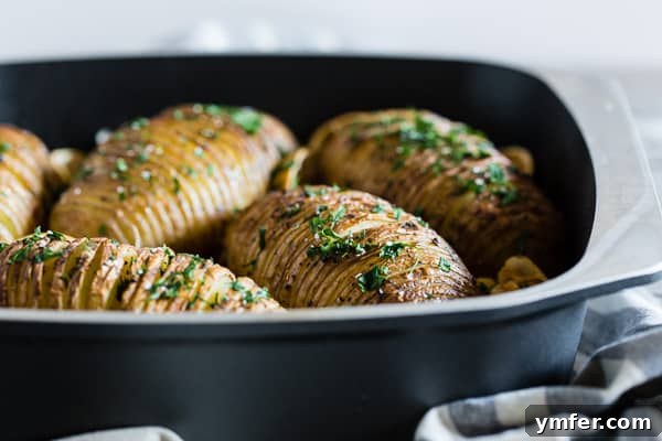 Zesty Herb Hasselback Roasties 3 Close-up of a beautifully sliced Hasselback potato with lemon and herbs before roasting.