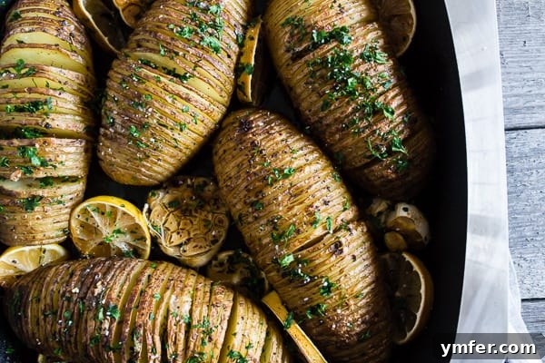 Zesty Herb Hasselback Roasties 5 Roasted Lemon Herb Hasselback Potatoes in a baking dish, garnished with fresh parsley.