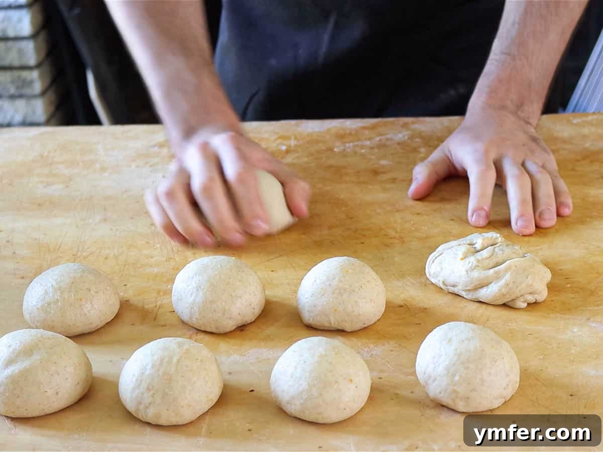 Heavenly Vegan Brioche 9 Hands carefully rolling individual portions of vegan brioche dough into neat balls, preparing them for the next proofing stage.