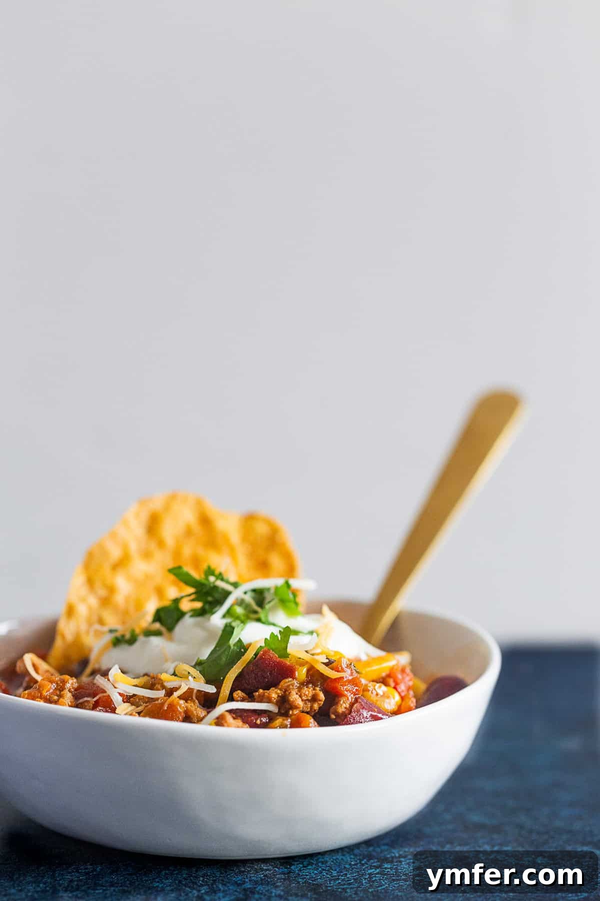 Smoky Chipotle Turkey Chili 5 A spoon scooping up a hearty portion of Chipotle Ground Turkey Chili from a bowl, highlighting its rich, thick texture.