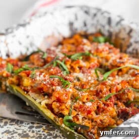 Final plated image of Chicken Parmesan Stuffed Zucchini Boats, showing the rich filling and melted cheese.