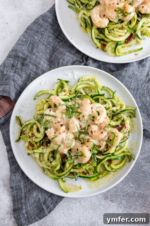 Vibrant Garlic Shrimp Pesto Zoodles 5 Overhead shot of garlic shrimp pesto zoodles, highlighting the fresh basil and red pepper flakes.