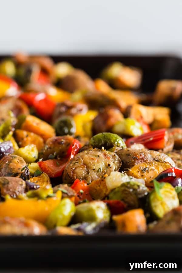 One-Pan Roasted Chicken Sausage and Garden Vegetables 4 A freshly baked sheet pan featuring golden-brown chicken sausage, roasted Brussels sprouts, bell peppers, and sweet potatoes, garnished with fresh herbs.
