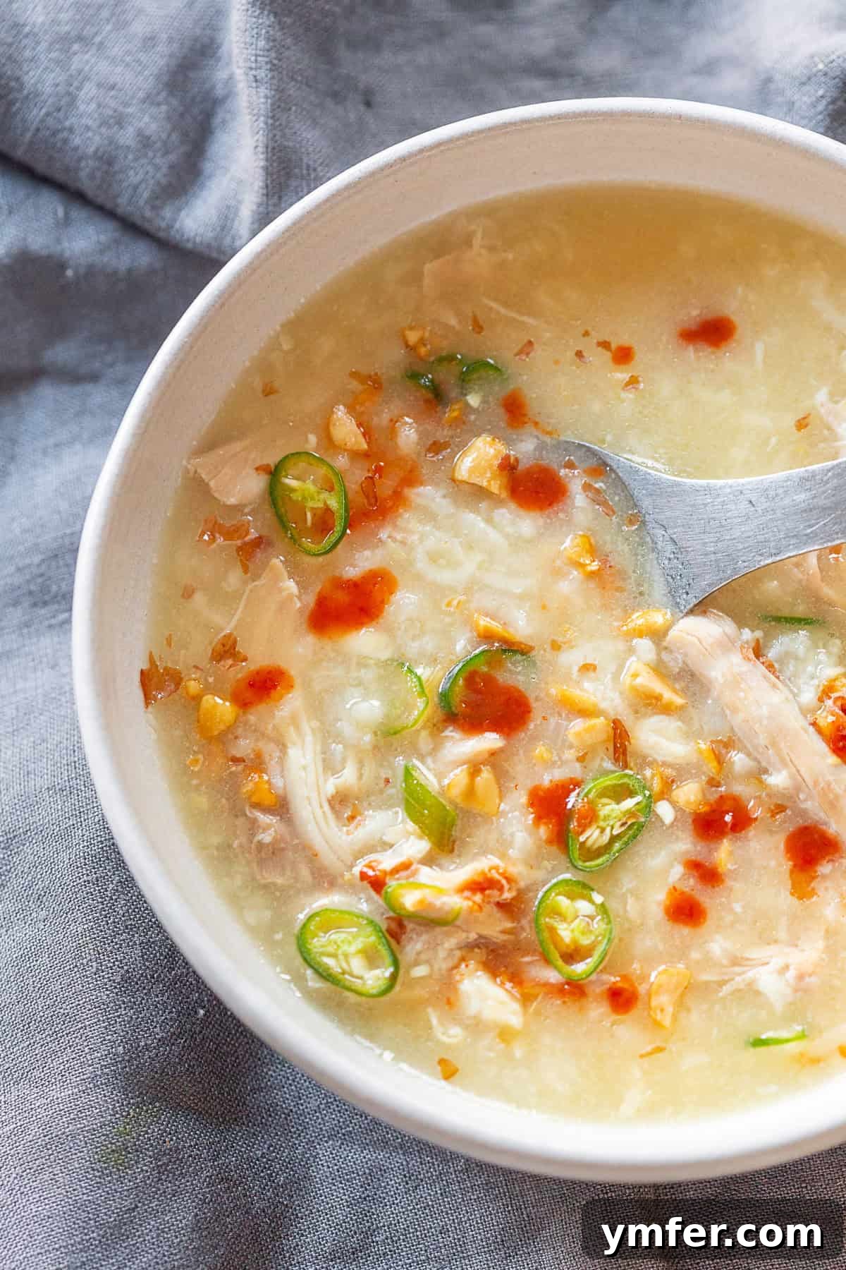 Comforting Instant Pot Asian Chicken Rice Soup 4 Instant Pot Asian Chicken and Rice Soup topped with peanuts, sriracha, and chilies.