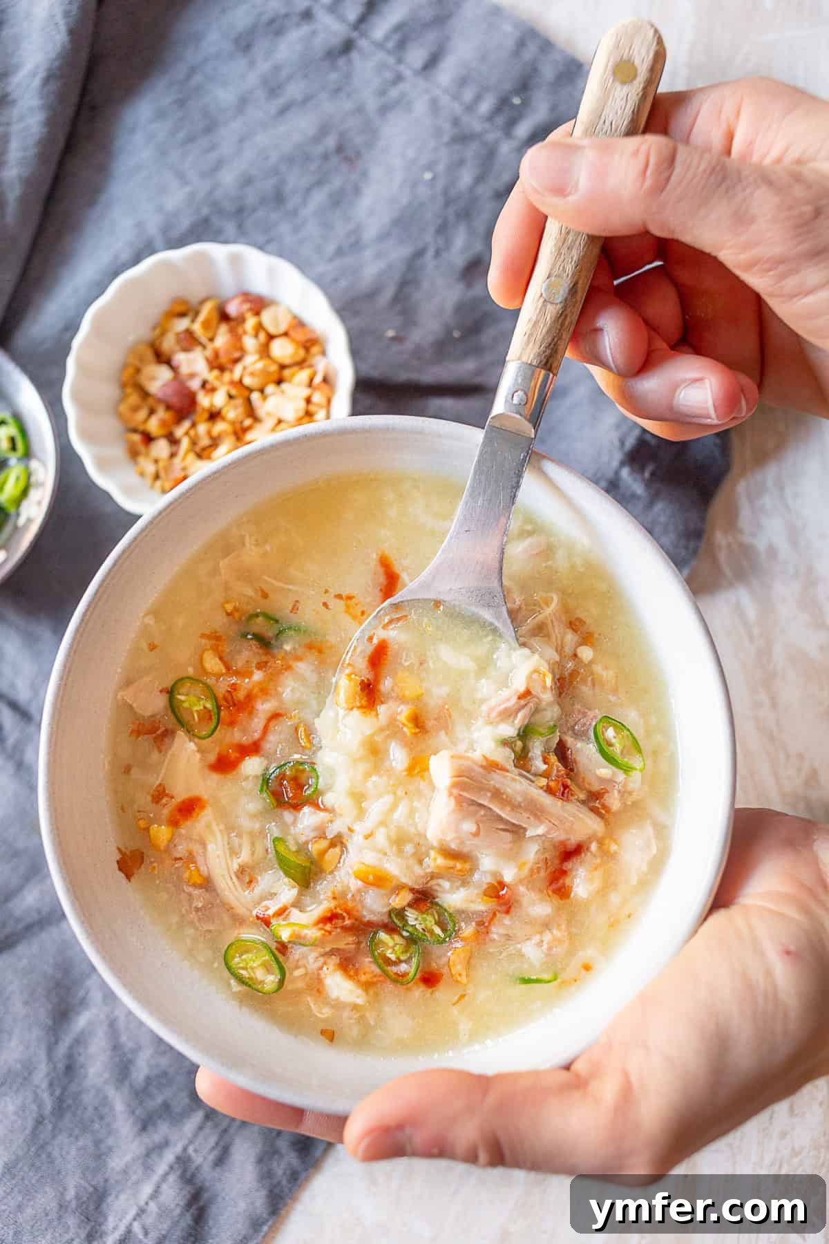 Comforting Instant Pot Asian Chicken Rice Soup 5 A person holding a bowl of Instant Pot Asian Chicken and Rice Soup.