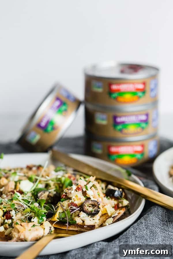 Zesty Mediterranean Tuna Flatbread 7 Mediterranean Tuna Salad Flatbread on a plate with a fork and knife.