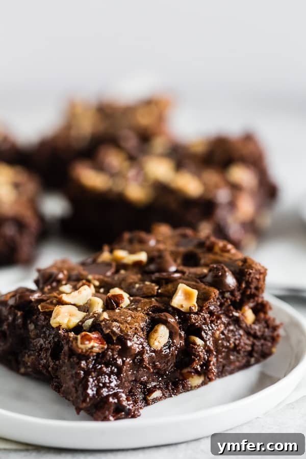A cut Hazelnut Buckwheat Brownie on a small white plate. 