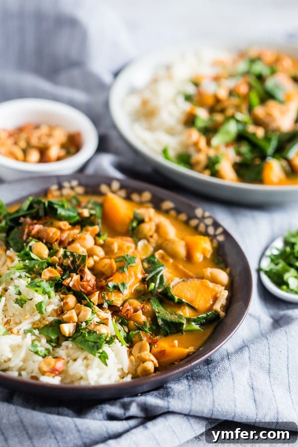 Soulful African Chicken and Peanut Stew 3 Close-up of African Chicken Peanut Stew in a ceramic bowl, topped with finely chopped peanuts and fresh cilantro.