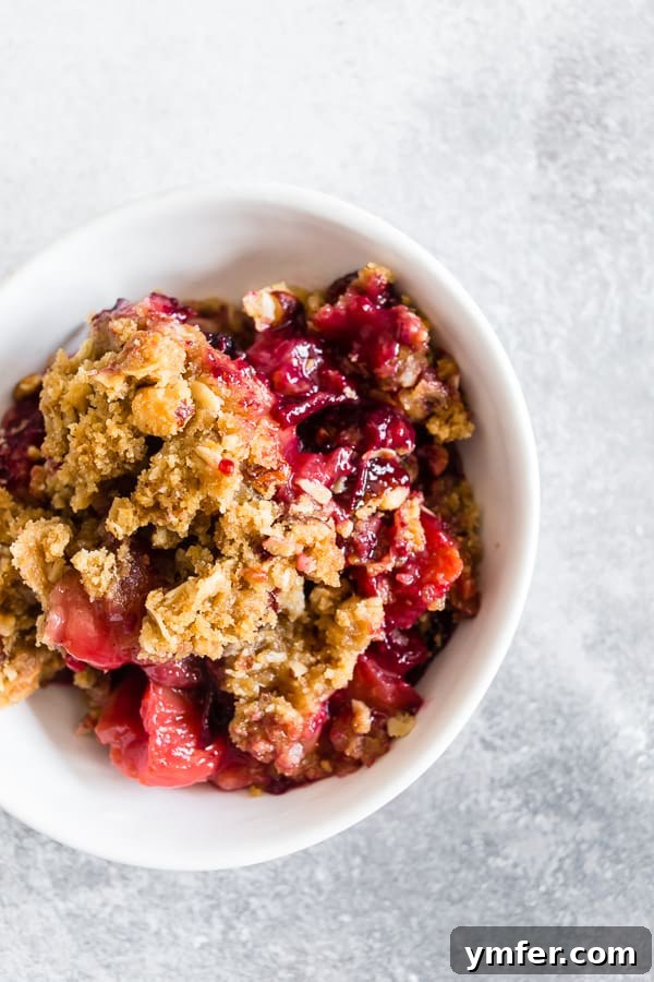 Cardamom Plum Crisp with Vanilla Bean 2 Cardamom Vanilla Plum Crisp spooned into a bowl, highlighting the juicy plums and crunchy topping.
