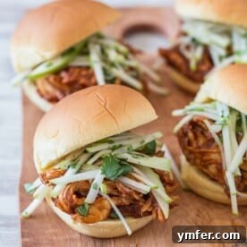 A hearty apple butter BBQ chicken sandwich served on a wooden board.