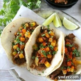 Flavorful chipotle apple butter carnitas, served on a plate with fresh toppings.