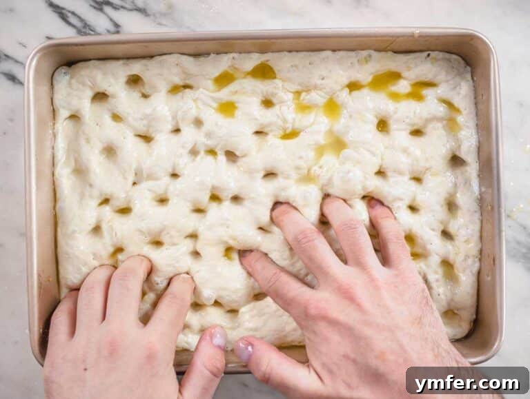 Golden Focaccia Perfection 18 Nico making dimples in the focaccia dough.