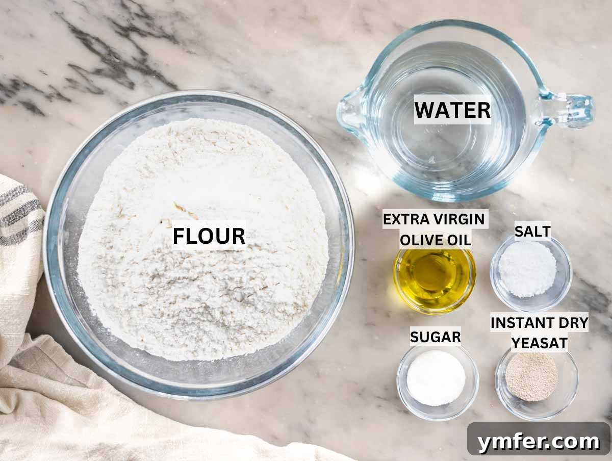 Golden Focaccia Perfection 4 Essential ingredients for baking homemade focaccia, including flour, olive oil, yeast, sugar, and salt, artfully arranged on a clean marble surface.