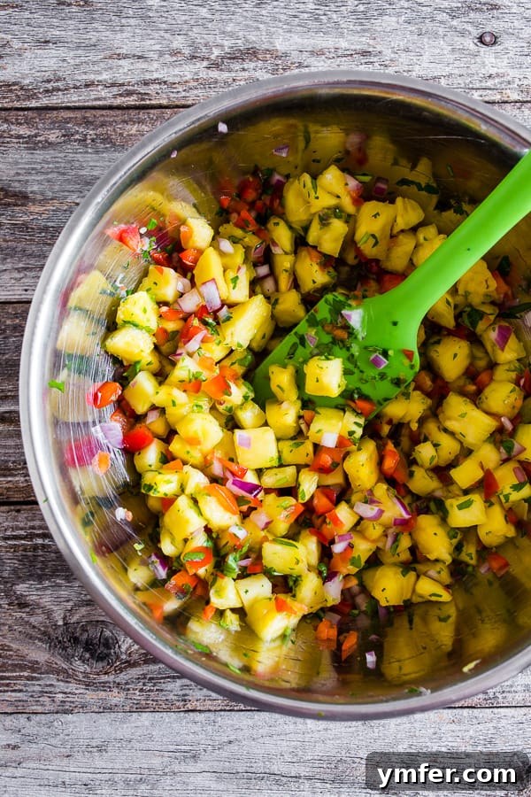 Aloha Pork Tacos with Pineapple Salsa 3 Overhead view of several ground pork tacos artfully arranged on a wooden board with fresh pineapple salsa.