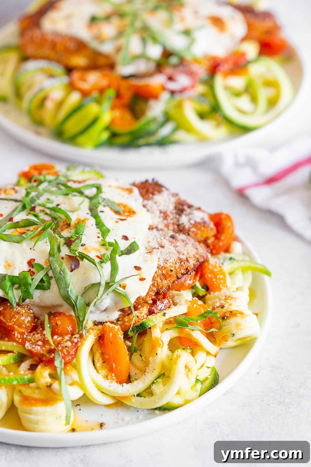 Summertime Zucchini Noodle Chicken Parm 5 Summer Chicken Parmesan with Zoodles served with fresh basil garnish.