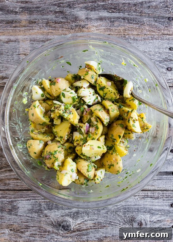 Sunshine Spud Salad 4 Honey Mustard Potato Salad being mixed in a large bowl, showing the vibrant ingredients.