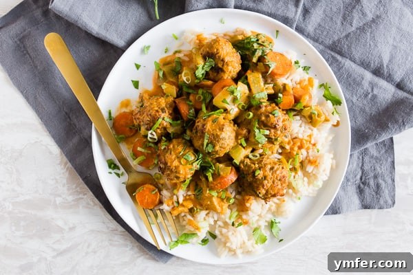 Zesty Red Curry Turkey Meatballs 3 A single Red Curry Turkey Meatball, cut in half, on a fork, showing its juicy texture.