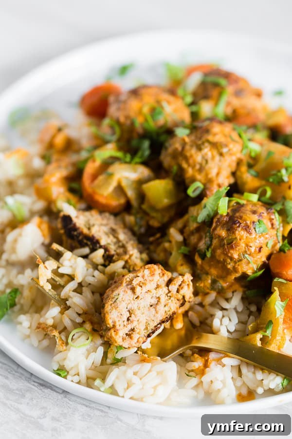 Zesty Red Curry Turkey Meatballs 5 A Red Curry Turkey Meatball on a fork, showing its soft interior and the rich sauce.