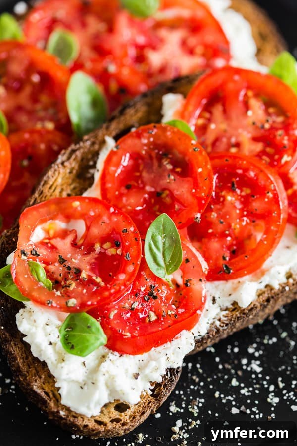 Tuscan Morning Toast 3 Close-up of tomato ricotta toast on a plate, adorned with salt and pepper crystals.