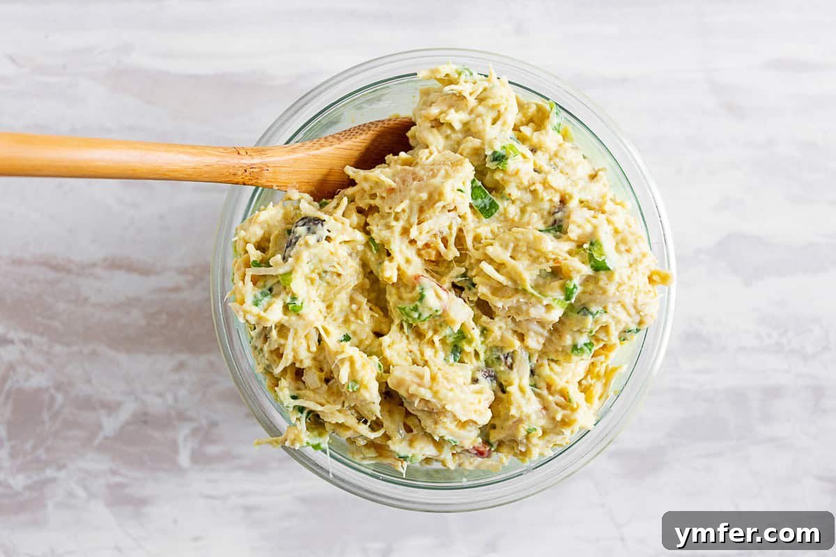 Zesty Curried Greek Yogurt Chicken Salad 3 curry chicken salad in a small glass bowl. A small glass bowl filled with vibrant curry chicken salad, showing off its creamy texture and colorful ingredients.