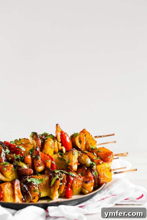 Island Pineapple Chicken Skewers 3 Grilled Pineapple Chicken Kebabs arranged artfully on a black plate, showcasing their perfect char.