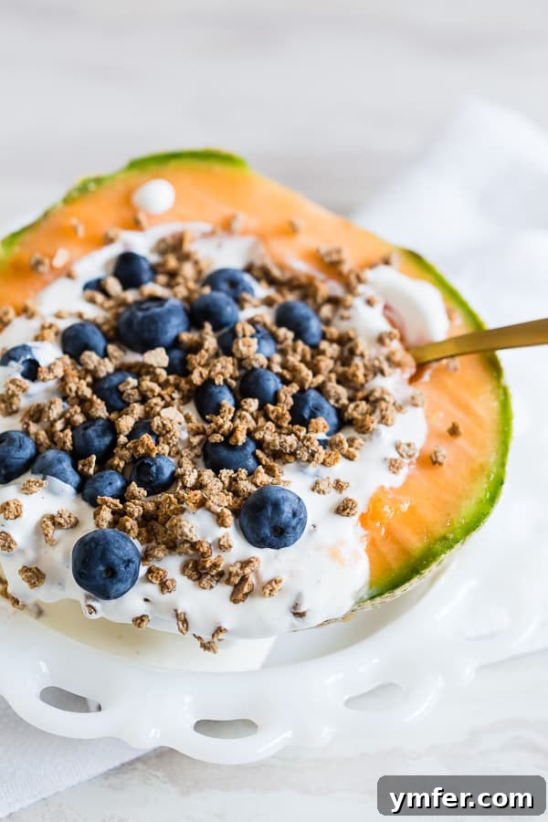 Close-up of a Crunchy Yogurt Cantaloupe Breakfast Bowl, highlighting the texture of Grape Nuts and the vibrant color of blueberries, ready to be enjoyed.