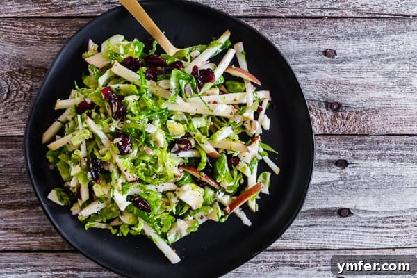 Zesty Apple & Brussels Slaw 5 Tangy Brussels Sprout Apple Slaw served with a fork, ready to be enjoyed.