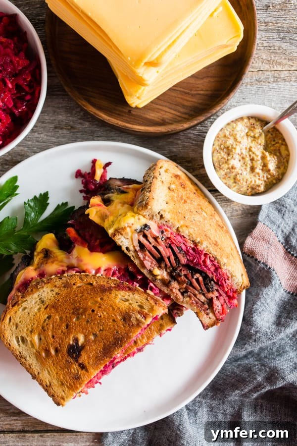 Grilled Pastrami and Root Slaw Sandwich 3 Grilled Pastrami Sandwich with Root Vegetable Slaw, perfectly sliced and presented on a plate, showcasing its delicious layers.